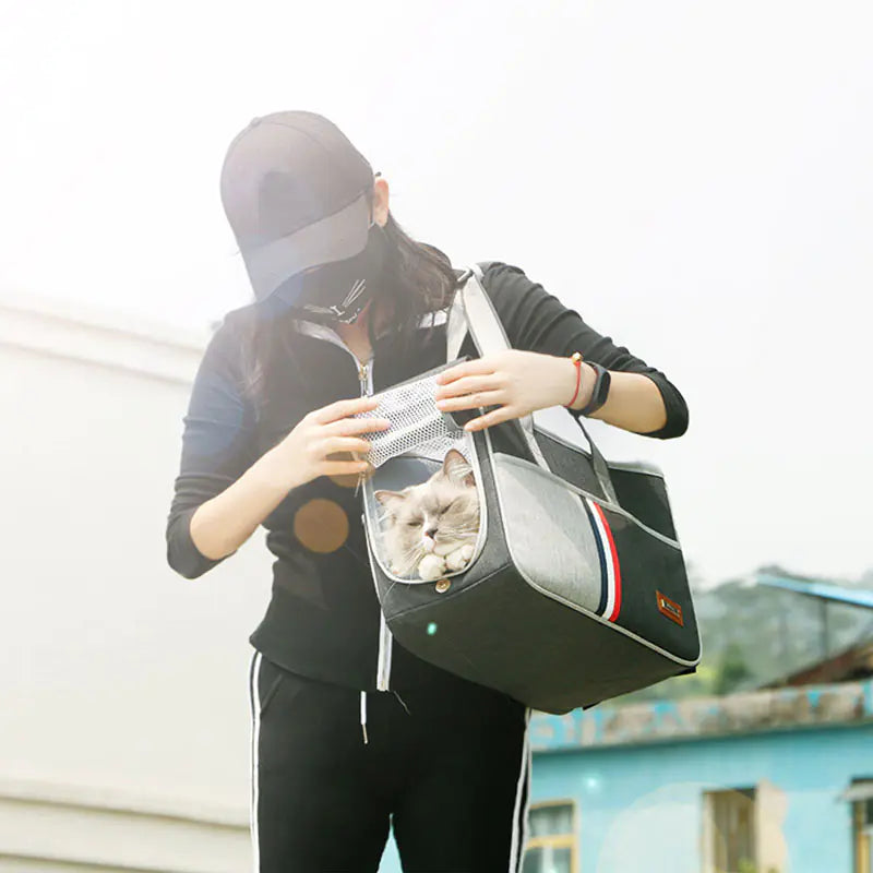 Woman carrying a cat in a breathable pet carrier backpack, perfect for comfort and safety on outdoor adventures.