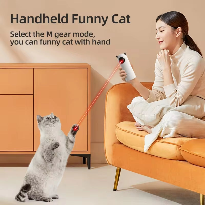 Interactive smart cat toy in use, showing a person using the handheld laser to play with a curious cat indoor