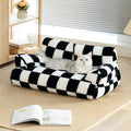 Cat lounging on a washable fluffy pet couch bed with black and white checkered design for ultimate comfort and relaxation.
