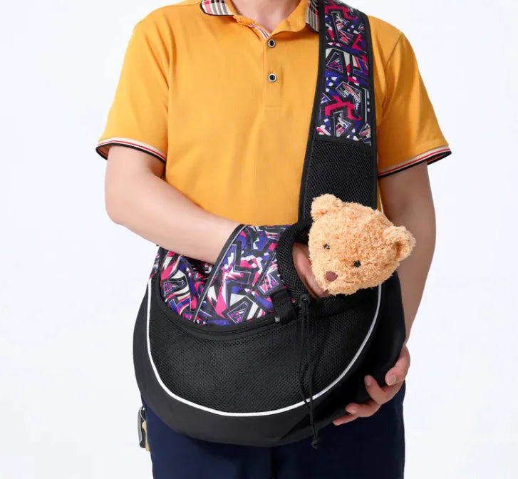 Person holding pet travel carrier bag with teddy bear inside, showcasing durable and breathable design for dogs and cats.