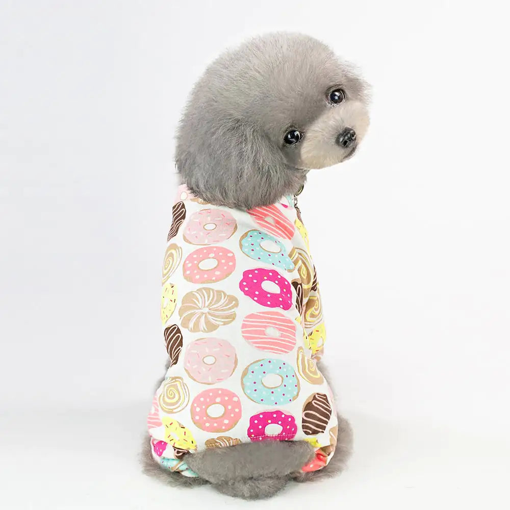 Small dog wearing cartoon fruit dog pajamas with colorful fruit pattern, showcasing four-legged cotton pet clothes available in sizes S-2XL.