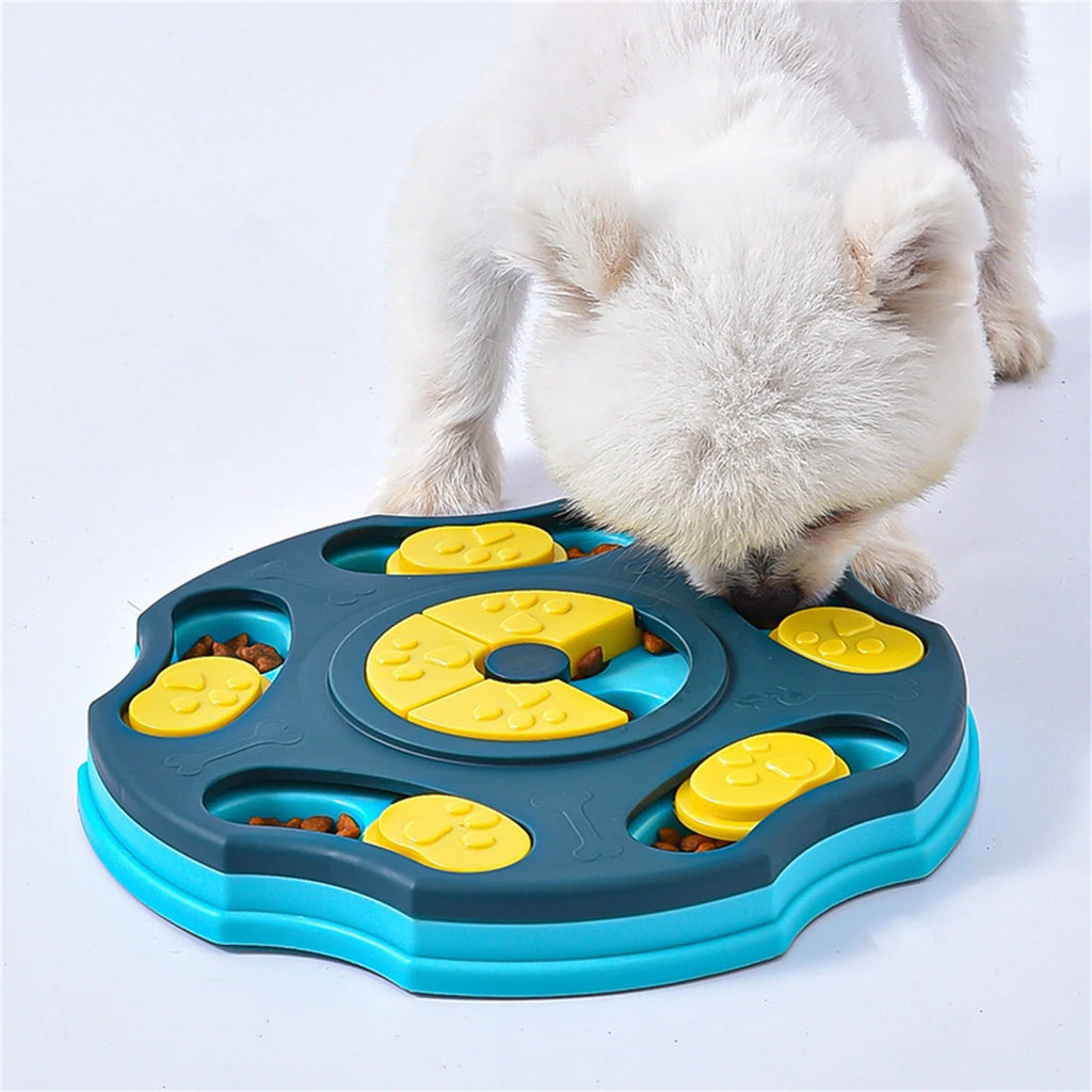 Small dog eating from an interactive dog puzzle bowl with food compartments and sliding covers, promoting slow feeding and mental stimulation.