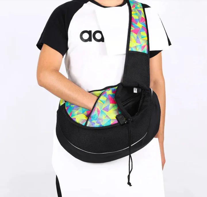 Person holding a colorful pet travel carrier bag for dogs & cats, ideal for comfortable and secure trips.