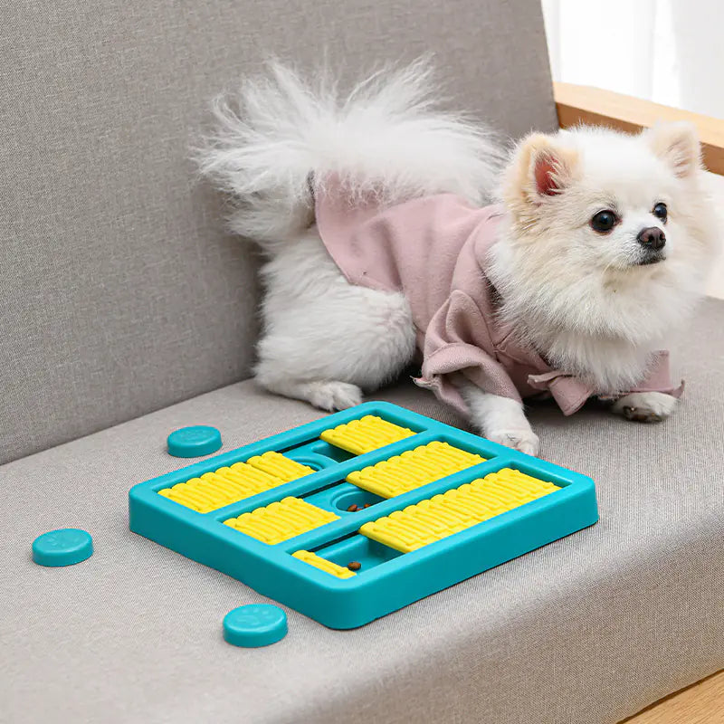 Small dog playing with interactive dog toy food dispenser on a couch, featuring a rotating slow feeder for mealtime fun.